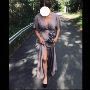 Balklänning - Lila balklänning/aftonklänning med slits framtill och band/rosett i midjan  Har endast använt den en gång, så den är i nyskick