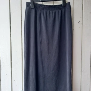 Wrap Monki skirt - Soft, lightweight fabric. 70% modal, 30% polyester.  Waist width (unstretched) 35 cm. Width at the bottom 54 cm. Length 76 cm.  The color is dark grey/asphalt!