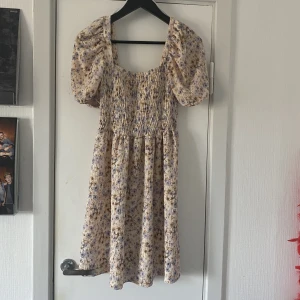 Sommarklänning  - Säljer denna fina sommarklänning som knappt har används. Blommigt mönster med en rosa ton i färgen, puffiga ärmar som är luuftiga. I storlek S