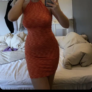 Orange klänning - Orange klänning. Använd 1 gång. Fin till fest eller stranden! Storlek M men sitter som S. Öppen i ryggen, knytband i nacken