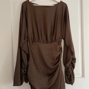 Fest klänning Hanna Schönberg - OANVÄND!! brun klänning från Hanna Schönbergs kollektion med NA-KD. Den är lite för liten för mig så därför har den aldrig kommit till användning, lappen hänger kvar. 