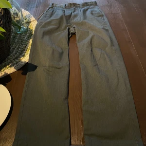 Dickies Kostymbyxor i Grå - Hej, säljer ett par riktigt snygga Dickies kostymbyxor i storlek 30 32. Köpta på Junkyard för runt 800kr. De är i bra skick men har lite slitningar vid fotöppningen, DM för bilder. Ledig och straight fit. Priset är inte hugget i sten. Hör av dig.