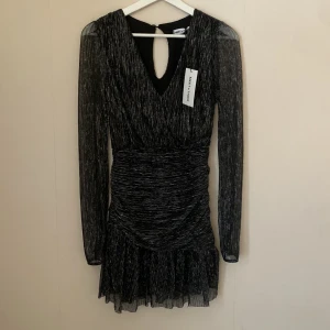Glittrig svart klänning - Helt i nyskick bara provad. Nypris är 500 kr. Super fin klänning från meet me there som passar perfekt till nyår, fest eller bara som en finklänning. Kan postas innan midsommar. 