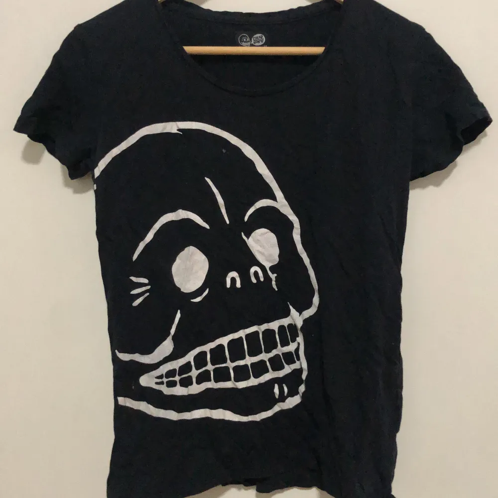 Svart t-shirt med tryck på skelett. T-shirts.