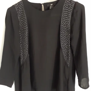 Enkel fintopp med silver detaljer. - Enkel fintopp med silver detaljer. Svart polyester.