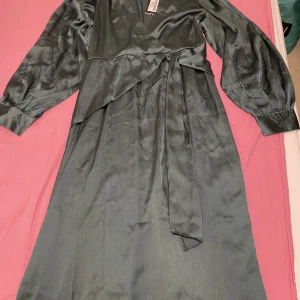 Klänning - Helt oanvänd klänning i storlek 44 som säljs. En långklänning med armegrön färg 