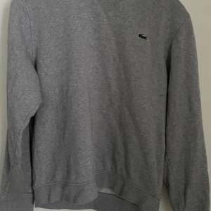 Lacoste grå sweatshirt 500kr - Grå Lacoste sweatshirt. Använd Max 10 gånger 8/10 skick. Den är lite nopprig på insidan men annars inga tecken på användning. Storlek: M men sitter lite tajt på mig så skulle säga      S/M