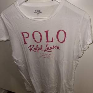 Vit tisha från Ralph Lauren med märkesnamnet tryckt i rosa. True to size! Fint skick