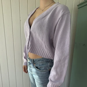 Kofta - Liten lila söt kofta med tre knappar där fram. Kan användas som en tröja också. Croppad design, aldrig använd!