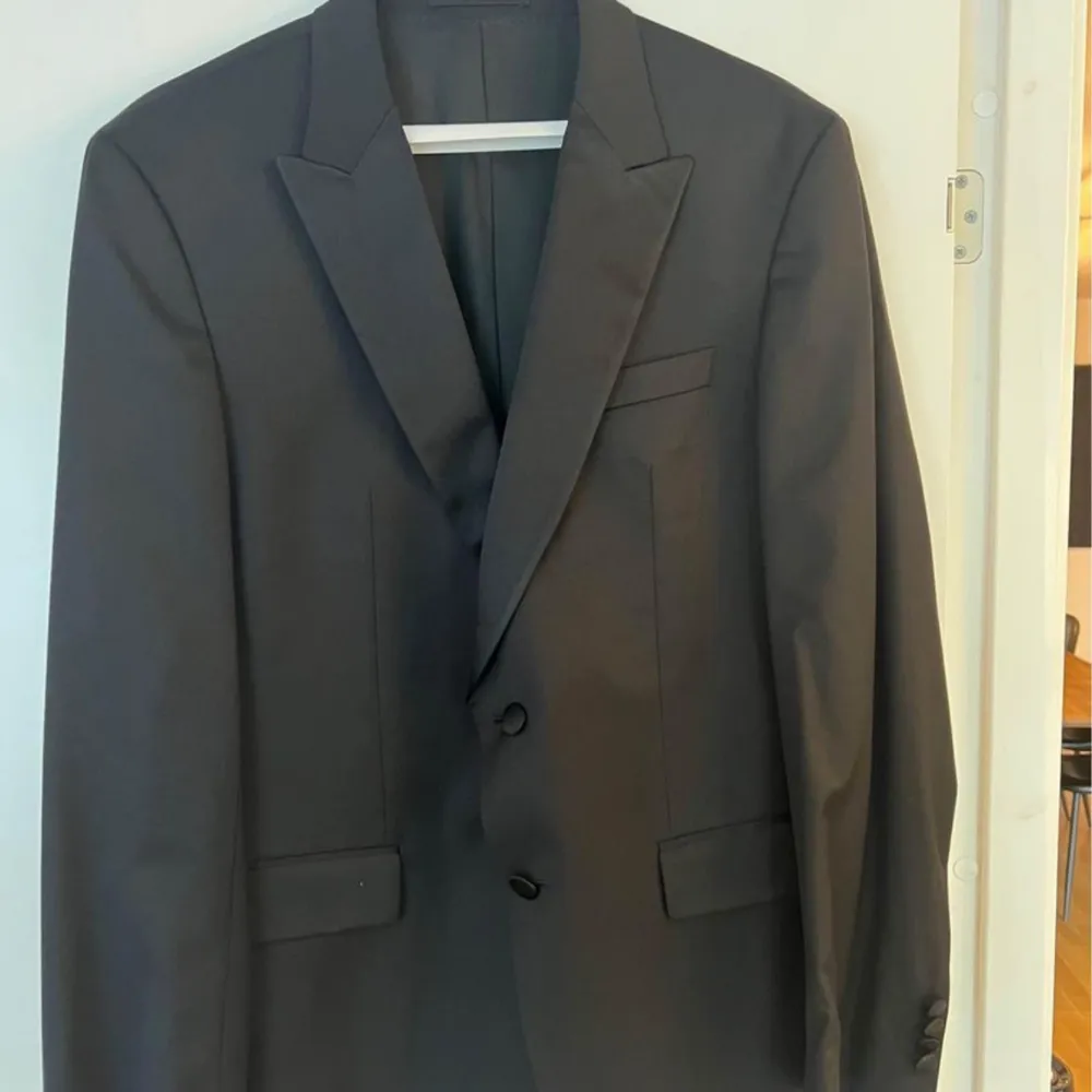 Hugo Boss tuxedo köpt på Emporia Malmö och är i nytt skick. Använd en gång och den har nyligen lämnats på kemtvätt.  Kostymgarderoben medföljer.  Kavajen är storlek 52 och byxorna storlek 50. Nypris 10.000kr  Mitt pris 3000kr . Kostymer.