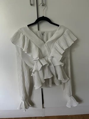 Vit volang tröja  - Hej hej!  Säljer min fina Volang tröja från Nelly då den ej kommer till användning. Använts fåtal gång.