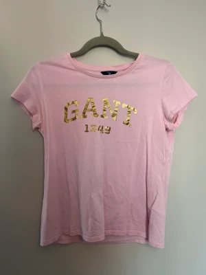 Rosa Gant T-shirt  - Rosa gant T-shirt med guld tryck, bra kvalite 💗 Original pris 500 kr 