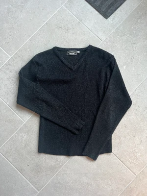 Glittrig tröja  - Svart tröja med v-ringning. Glittrig. Aldrig använd. Står att de är storlek 42/44 men sitter som XS. 