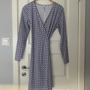 Klänning - Säljer denna superfina somriga klänning ifrån Bubbleroom. Knappt använd och därav i superbra skick. Skulle säga att den passar xs-m då den är i väldigt stretchiga material, samt omlott så man väljer själv hur tajt man vill ha den!💓