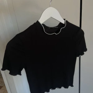 Zara topp - Svart ribbad topp från zara, med vita kanter. Tajt passform, men väldigt stretchig.