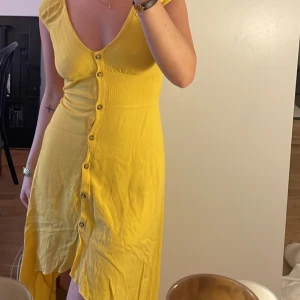 Klänning  - Superfin gul sommarklänning! Jätteskönt och mjukt material. Kommer ej till användning hemma hos mig. Köpt i Kanada i storlek M men mer som en xs. 