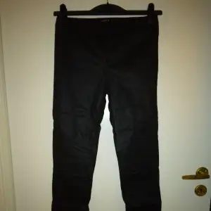 Svarta vaxade treggings, Strlk: 36/XS-SMALL. Från Lindex.  Har resår i midjan. Snygga sömmar på benen, vid knäna bla. Ingen gylf. Felfria.