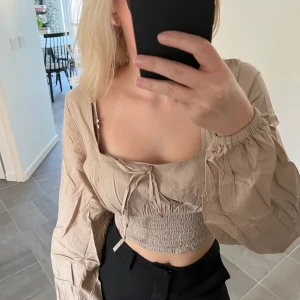 Beige topp - Säljer denna beigea toppen som passar både till vardags och fest. Den är aldrig kvädne och prislappen finns kvar