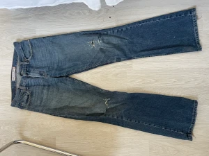 Levis jeans - Low bootcut jeans med slitningar. Bakfickan är trasig därför det billiga priset. Storleken står inte men skulle säga att den passar s-m. 