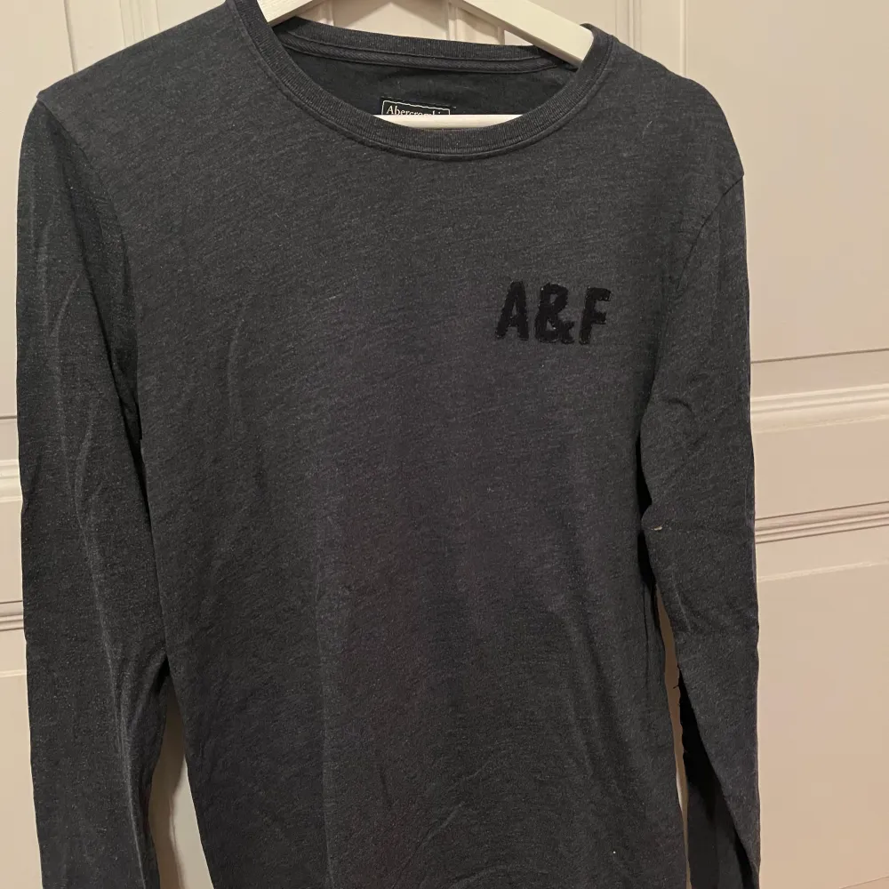 En långärmad mörkgrå tröja från abercrombie & fitch! Den är i bra skick och i storlek Xs för män🙌. Toppar.