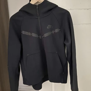 Helt ny Nike Tech Kofta  - En helt ny Nike tech kofta som är använd bara 1 gång i maximalt 5 timmar, säljs pga fel storlek och borttappat kvitto. Därför kan jag ej lämna tillbaka den, byxorna finns till och är också helt o använda. Man kan få köpa hela sättet elr delarna separat. 