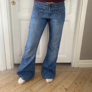 Lågmidjade jeans - De perfekta lågmidjade jeansen med coola detaljer💗 Perfekt skick! Utsvängda i benen🤩 Skriv vid funderingar! Kolla gärna in mina andra annonser❣️