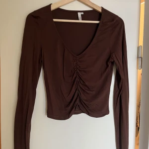 Tunn tröja  - Tunn brun tröja med rynkning i mitten. Ifrån Nelly,  storlek M