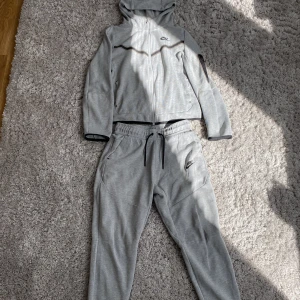 Nike tech fleece - okej skick. byxorna har ett litet hål i fickan och i grenen som man inte märker av. koftan är inte använd lika mycket som byxorna, har ett litet hål fram. Bild på hålen i byxan så är det bara att fråga. kan gå med på att bara sälja koftan eller byxorna.  