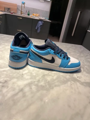 Jordan low white/dark Powder blu obsidian  - Hej jag säljer ett par aldrig använda  Jordan 1 low white/dark powder blu obsidian de är köpta på Merch sweden. De har aldrig andvänts för de blev för små imma jag han andvända köptes för 3100kr 