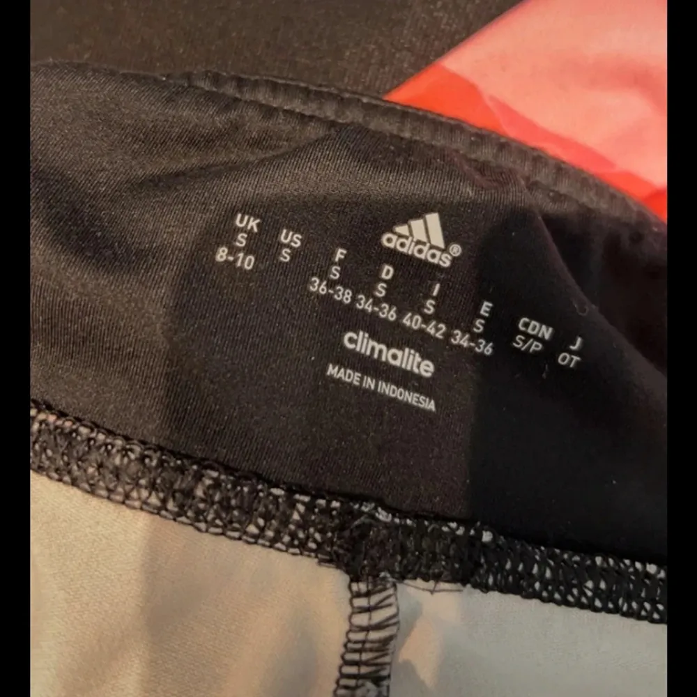 Träningstights från Adidas i svart/rött/rosa, jättesnyggt mönstrade. Brett band i midjan så de sitter bekvämt. Climalite-tyg, som andas. Storlek S (36-38) och i mycket gott skick utan defekter. . Jeans & Byxor.