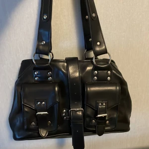 Väska - Säljer denna min mammas från 2000 talent ja ärvt av henne. Jag har inte använt den men hon har. Den består av tre fack och två små fickor på framsidan och ett bälte. Skriv för mer frågor eller bilder❤️