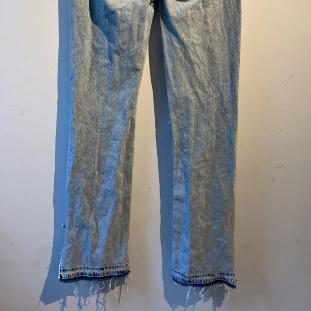 Blåa jeans som är lågmidjade, detaljer på fickan bak och nere vid benen, 1 hål i knäet. Jeans & Byxor.