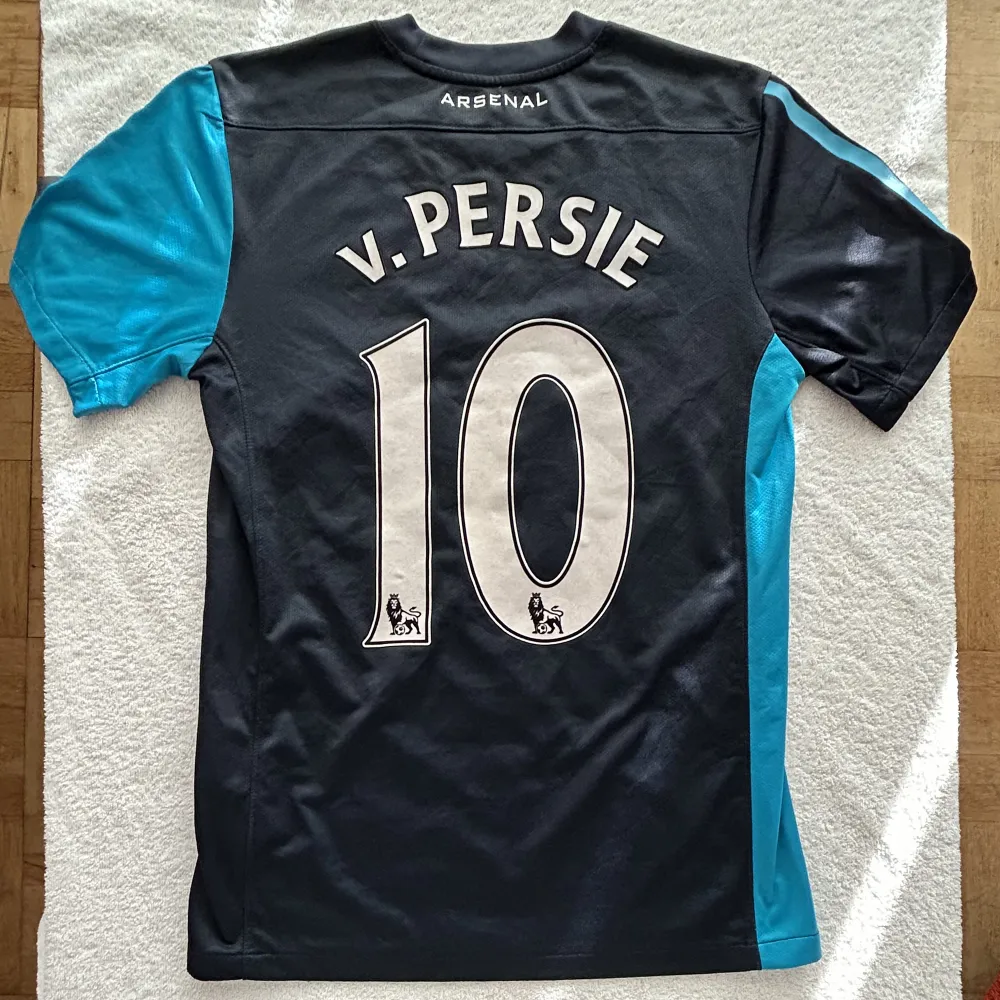 Arsenals bortatröja från 2011/2012 säsongen med stjärnspelaren Van Persie på ryggen.  Storlek: S Skick: 8/10. T-shirts.