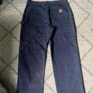 Carhartt carpenter - Säljer mina carpenter byxor då dem inte passar, fint vintage skick men med en fläck på insidan av högerbenet längst ner inget som märks av så mycket. På lappen står det att dem är 34/30 men dem passar mer som 32/30. 