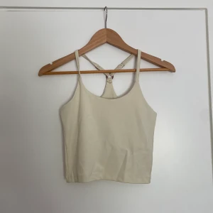 Halterneck träningsstopp  - Jättesnygg träningsstopp med inbyggd bh i halterneck skärning. Endast använd 2 gånger 