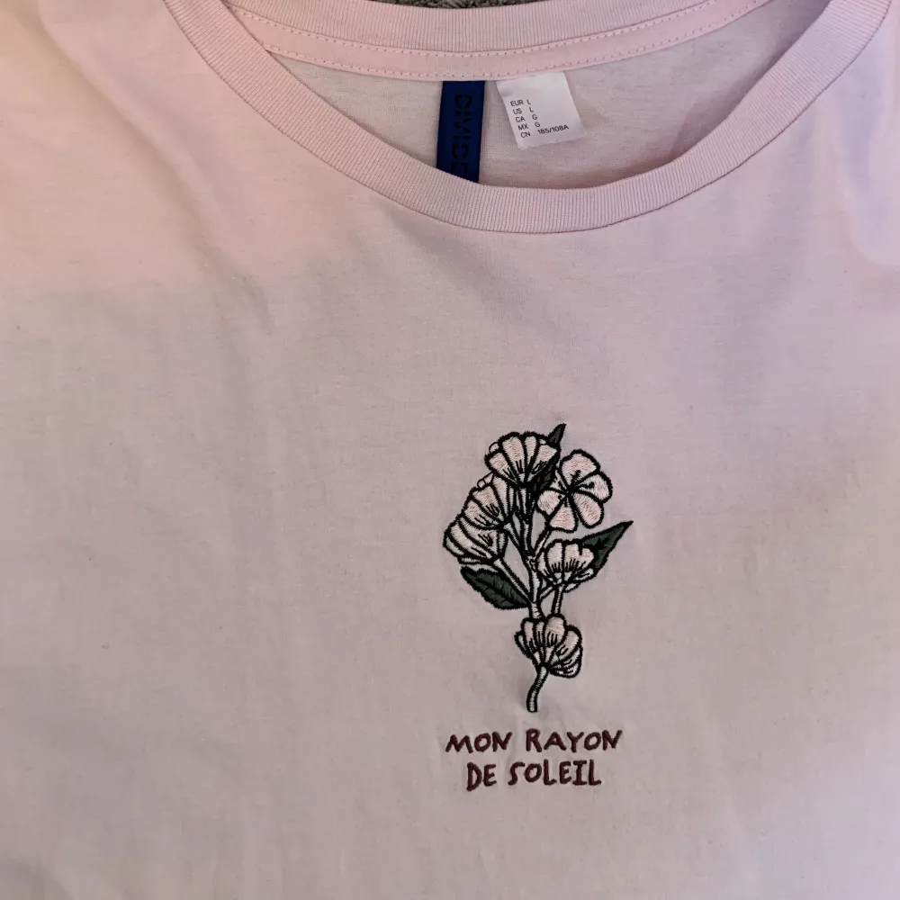 Oversized T-shirt som är rosa med en broderad blomma på framsidan och ett gulligt bildtryck på andra sidan. Köpt på H&M. Tryck gärna på köp nu :). T-shirts.
