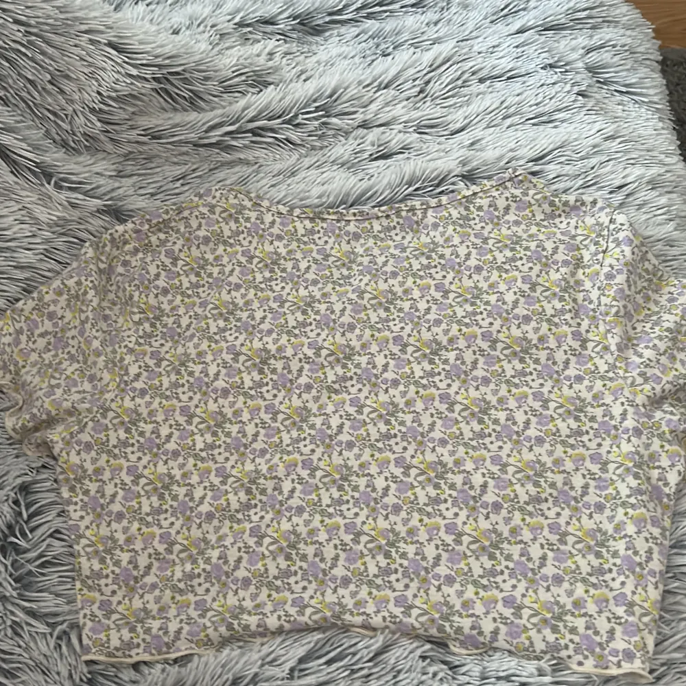 En vit tröja med lila och gula blommor på, bra skick storlek L, tror nypris va 50kr men är inte säker så säljer för 30💓. T-shirts.