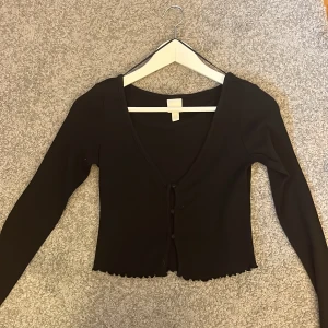 Hm topp/ kofta - Hej säljer denna snygga topp/ kofta då den inte kommit till andvändning passar perfekt till sommaren är i storlek xs men passar även s eller M då den är sträckor och att den har knappar som gör att den inte sitter så tajt💕