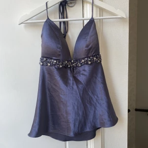 Satin topp - Satin topp med pärlor. Lite vadderade kupor. Öppen där bak med band som knyts. 