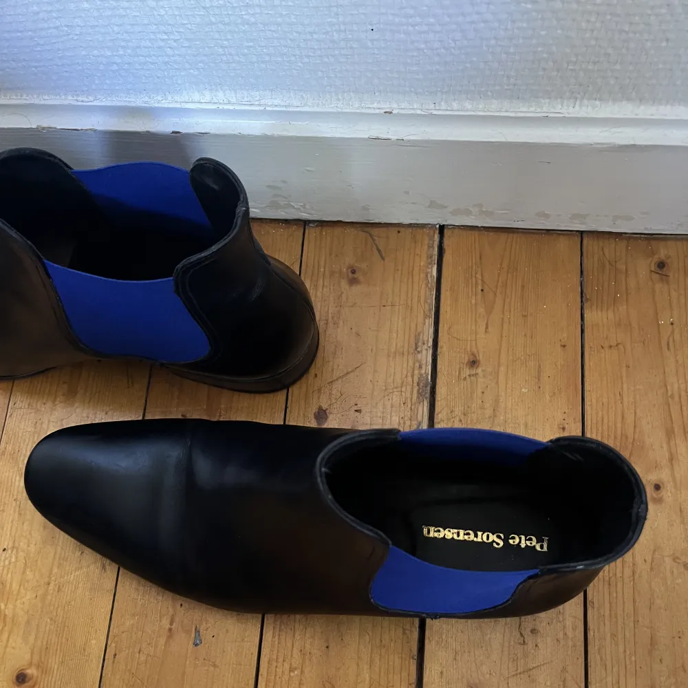 Knappt använda Pete Sorensen Phantom svart & blå skor i storlek 44. Väldigt bra skick. Handgjorda Chelsea boots tillverkad av ett enda läderstycke. Lätt och smidig italienskt kalvläder. Säljs nya av Pete Sorensen för 4450sek (380€). . Skor.