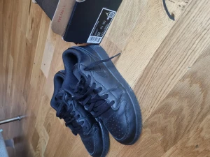 Nike Air Jordan 1 low (gs) - Ångrat köp haft på en enda gång. Svarta nike air jordan stl.38 med kartong köpte för 1200 kr.