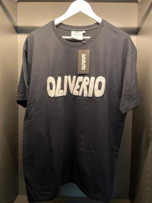 Original OLIVERIO Tee från en osläppt klädkollektion. Denna kollektion inkluderar t-shirts samt luv tröjor som är tillgängliga i begränsad upplaga.   - 100% bomull  - 120GSM  - Passform: Oversize  - Färg: Svart / Vit  SKICK: OANVÄND