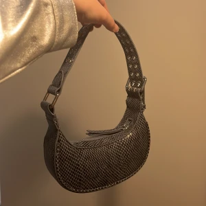 Blå ormskinn-aktigt läderväska från Urban Outfitters - Har aldrig använts Mått: 19cm bred och 5,5cm djup