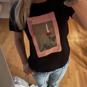 Svart T-shirt me tryck - Snygg tröja me ros på. Använd väll men bra skick. Inga deklarationer vad jag ser. Köparen står för frakt❤️
