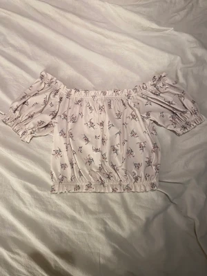 Of shoulder blommig tröja  - Of shoulder tröja med blommigt tryck i storlek M. Oanvänd tröja fråg Gina, med taggen kvar. Köpt för 159kr. 