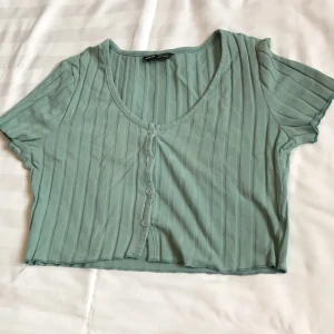 Blå-grön Croptop - - Plagg: Blå-grön - Mönster: Inget - Färg: Blå-grön - Storlek: M - Märke: Shein - Skick: Väldigt bra  - Egenskaper: Lettuce trim, croppad, knappad, ribbad, stretchig Kontakta mig gärna vid frågor 💕 