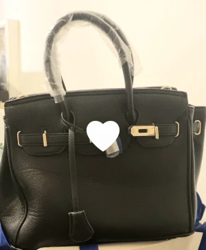 Klassisk Svart mellanstor axelremsväska  - Nytt skick ej använd pga fel köp så eftersom jag inte använder den hoppas jag den kan komma någon annan till nytta Fler bilder fås vid intresse 