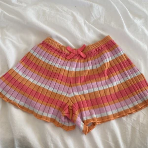 Pyjamasshorts - Midrise randiga mjukisshorts i färgerna rosa, orange och vit.🤍💕🧡 Är i barnstorleken 122-128 men passar xs-s då dom är stretchiga💓bra skick, frakten tillkommer💌