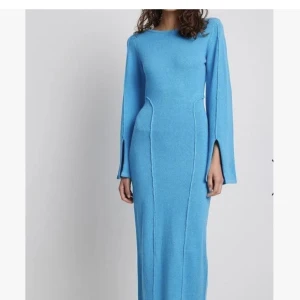 NAKD klänning  - Så snygg och skön stickad maxiklänning i turkosblå med breda ärmar och sömdetaljer. Nyskick. Storlek L. Nypris 1399:-.