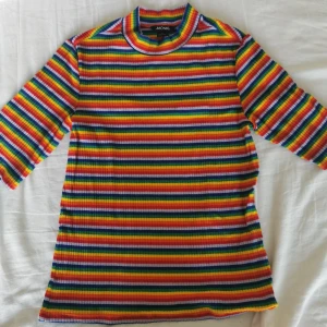 Regnbågströja - Åtsittande regnbågströja från Monki i strl M. Halvlånga ärmar.